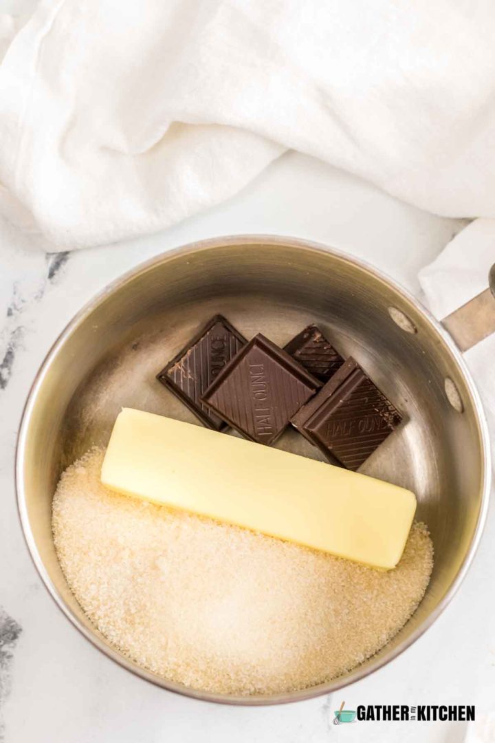 pan with chocolate pieces, butter, and sugar in it.