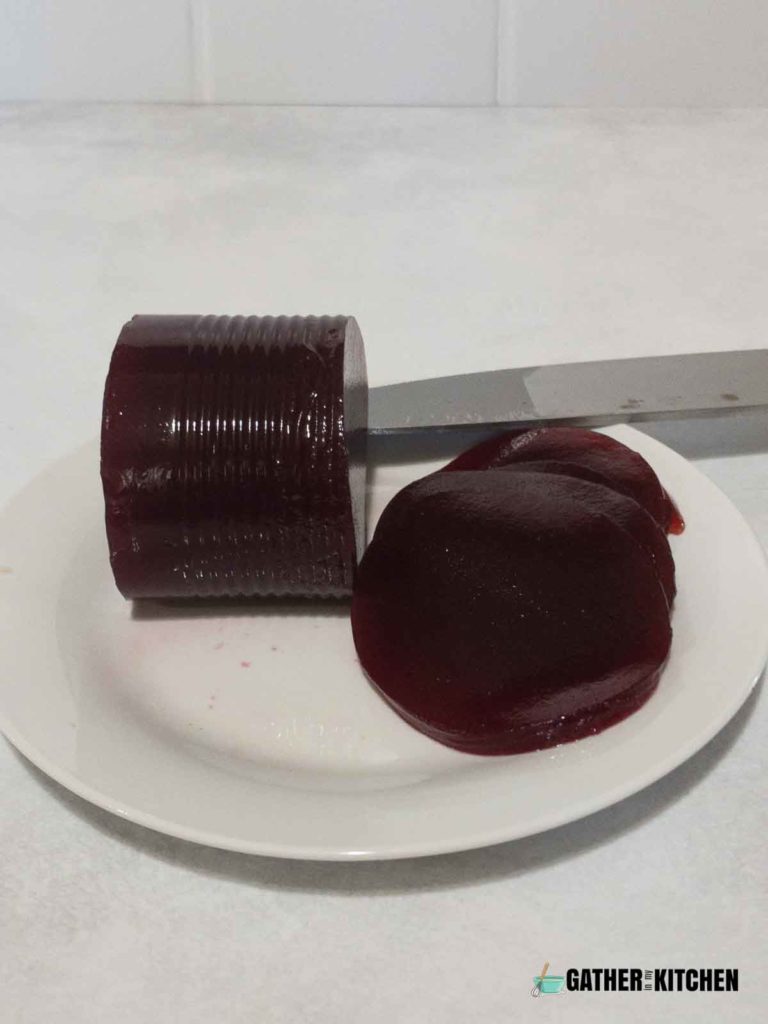 canned jellied cranberry sauce being cut.