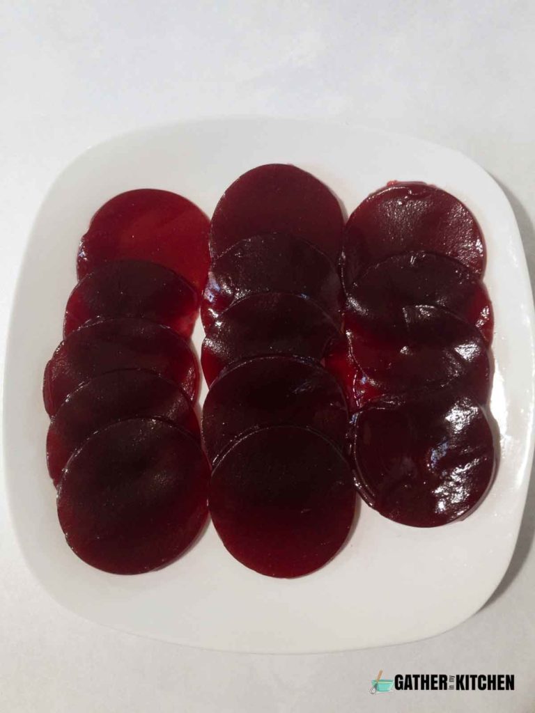 jellied cranberry sauce cut into rounds and displayed on a plate.