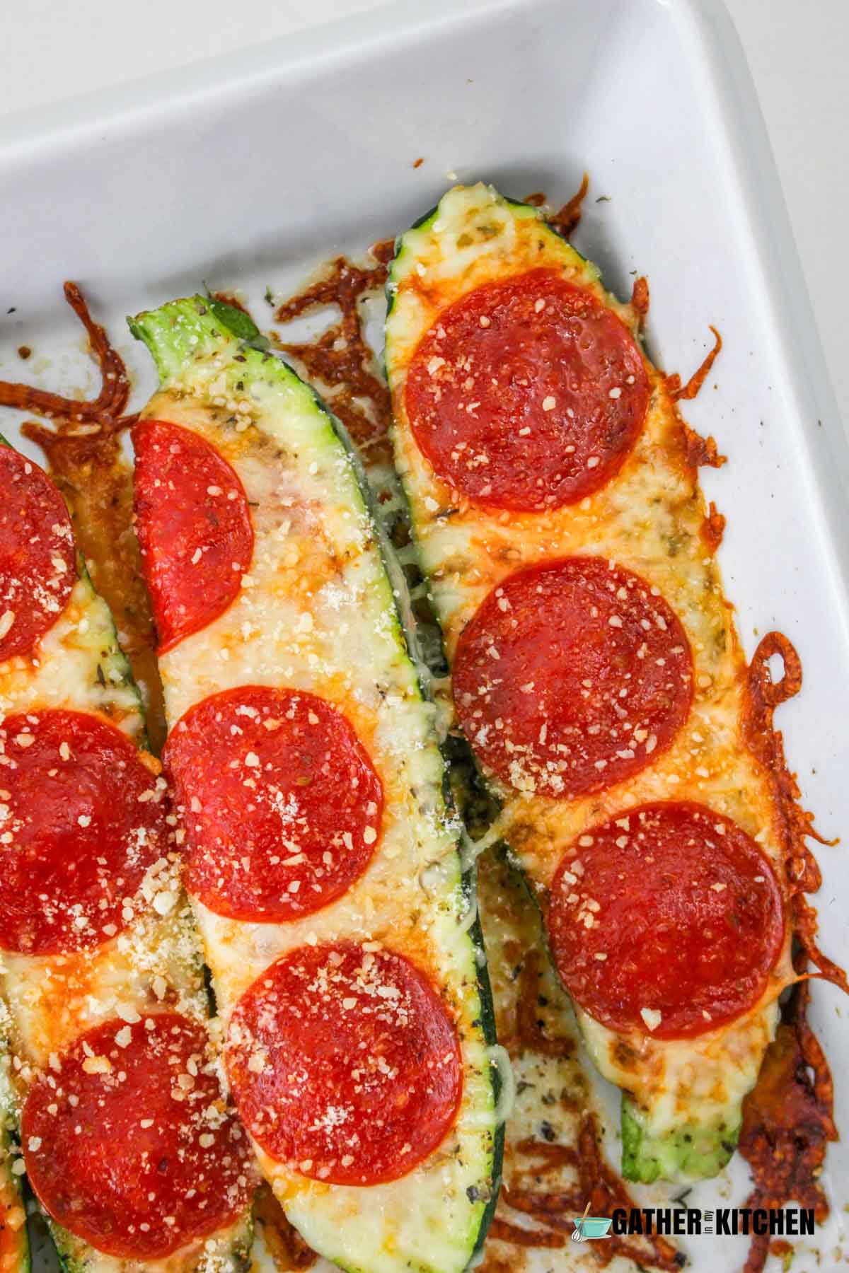 Closeup of zucchini pizza boats in casserole dish.