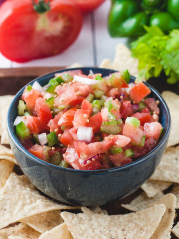 bowl of Pico de Gallo surrounded by chips.