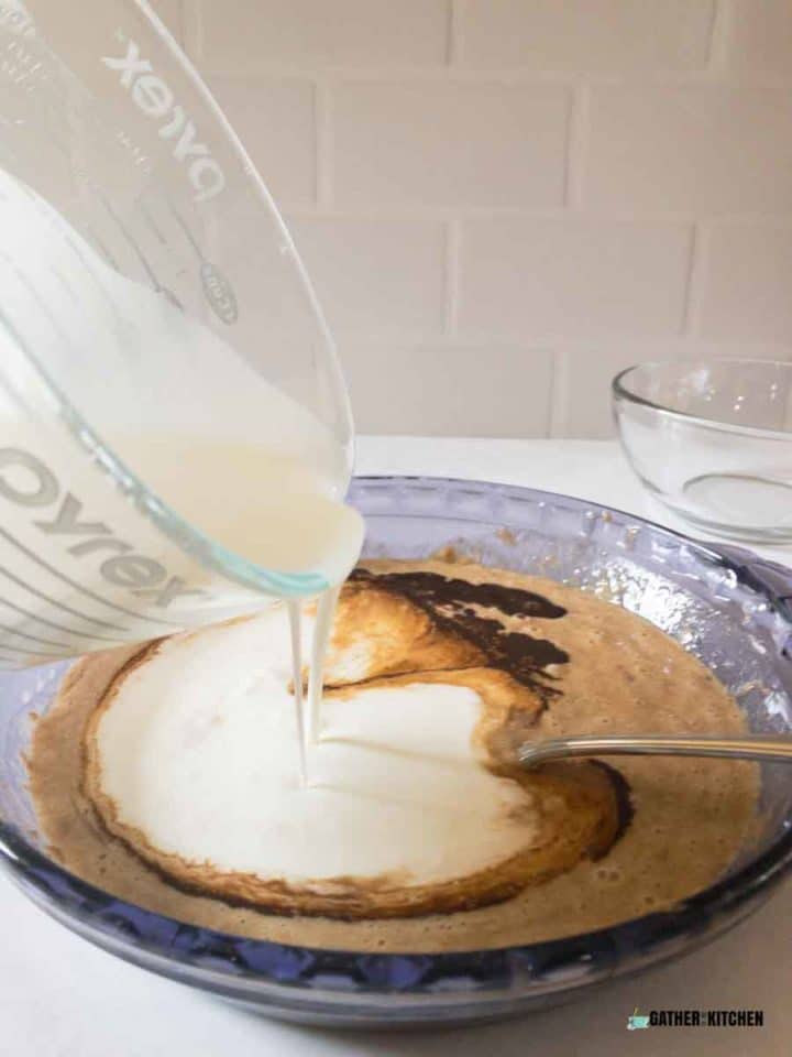 Pouring milk into the egg mixture.