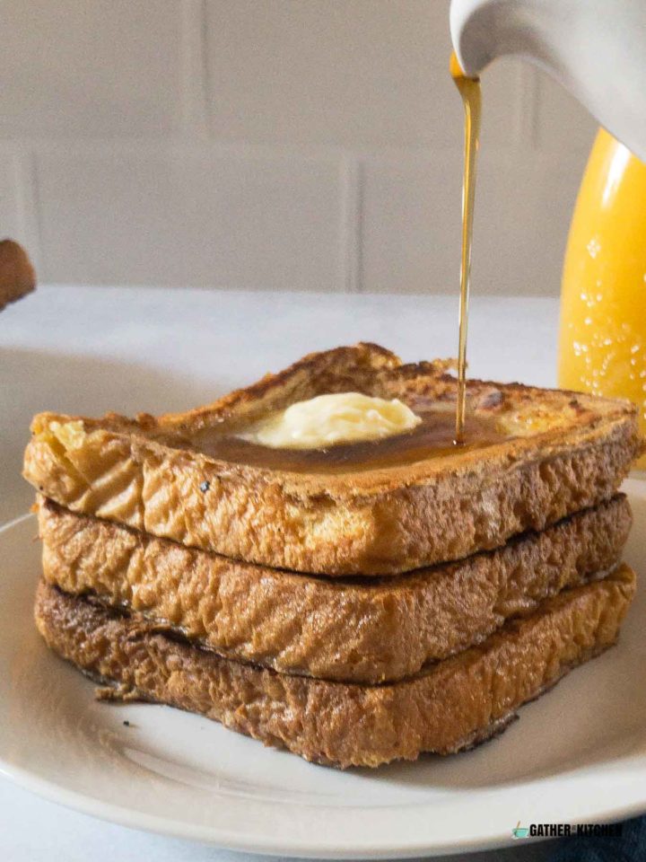 Pouring syrup on a stack of French toast.