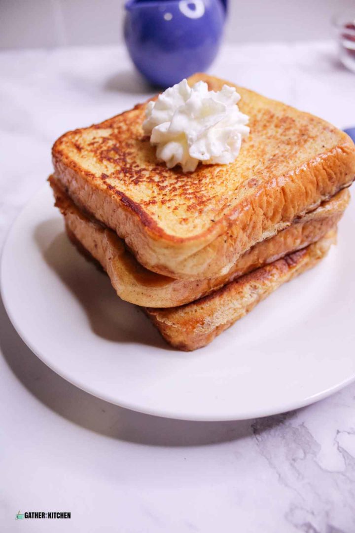 Stack of eggnog French toast on white plate.