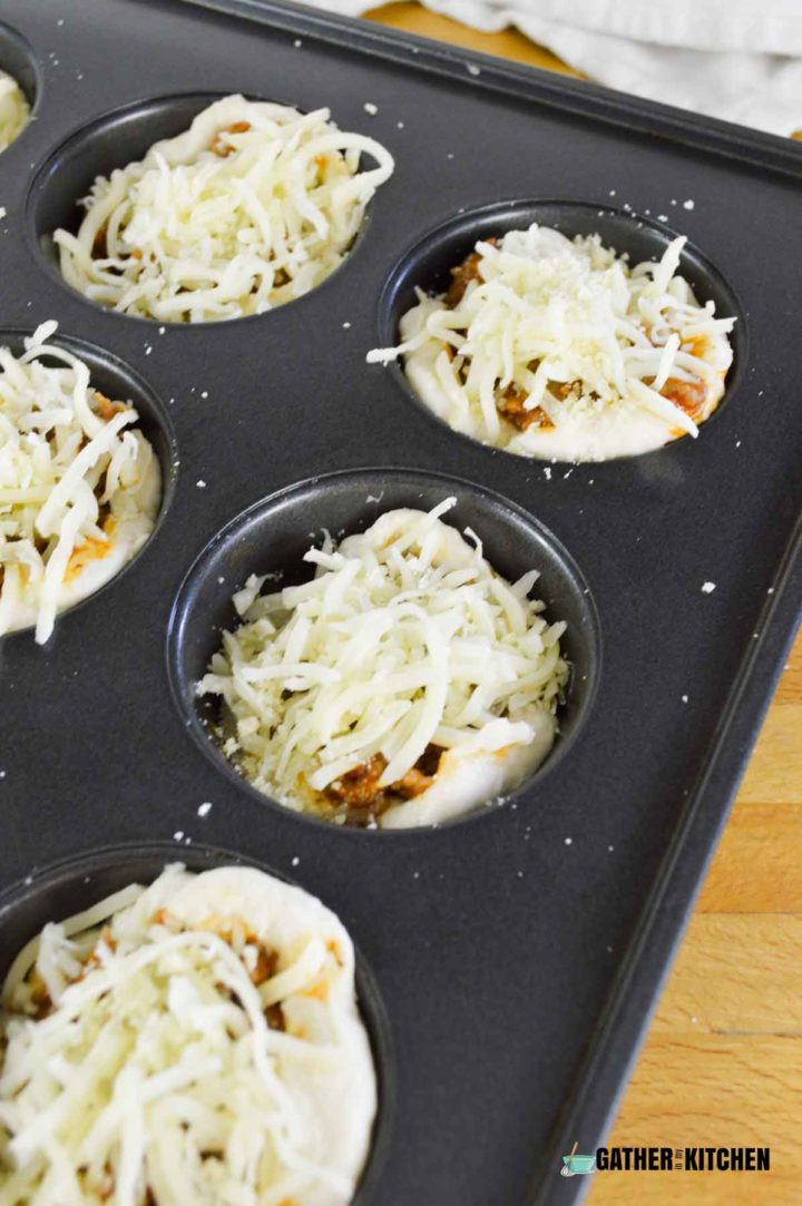 Cheese topped Italian sausage muffin cups in muffin tin.