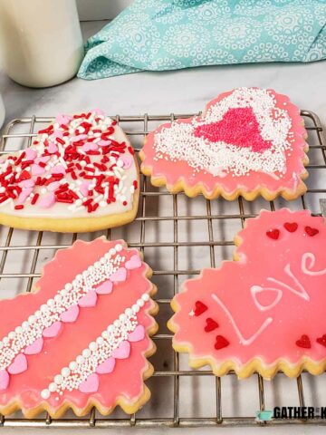 Decorated heart Valentine cookies on a wire rack.