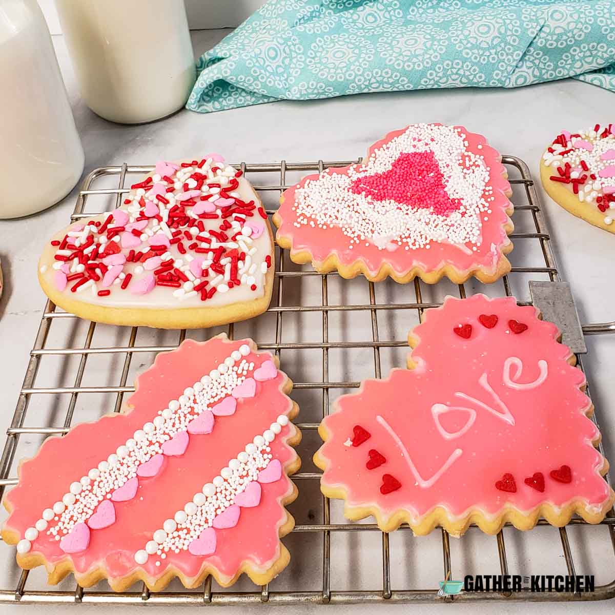 Decorated heart Valentine cookies on a wire rack.