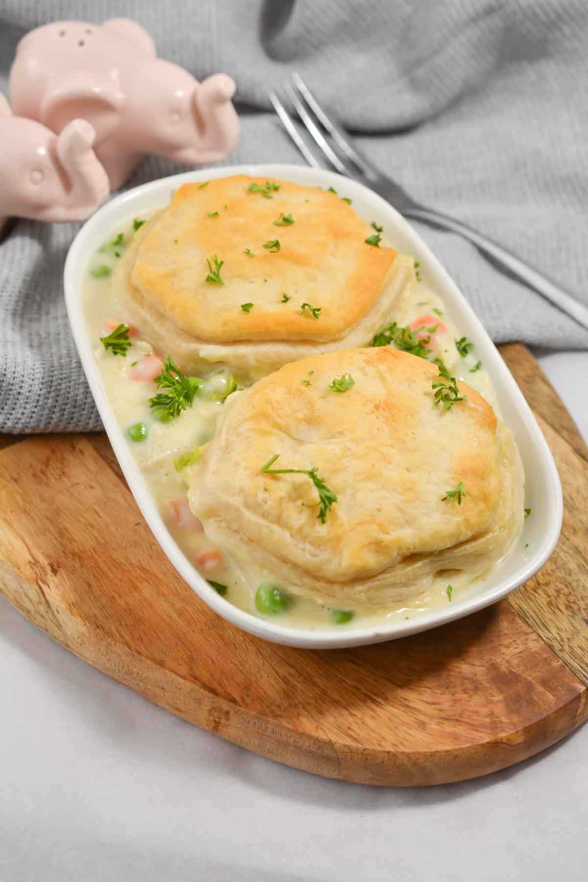 Side angle view of chicken pot pie with biscuits on a plate.
