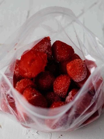 Plastic bag with frozen strawberries in it.