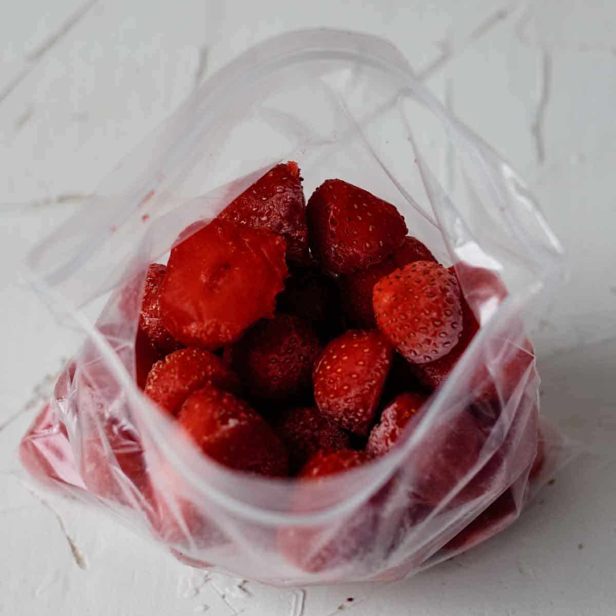 Plastic bag with frozen strawberries in it.