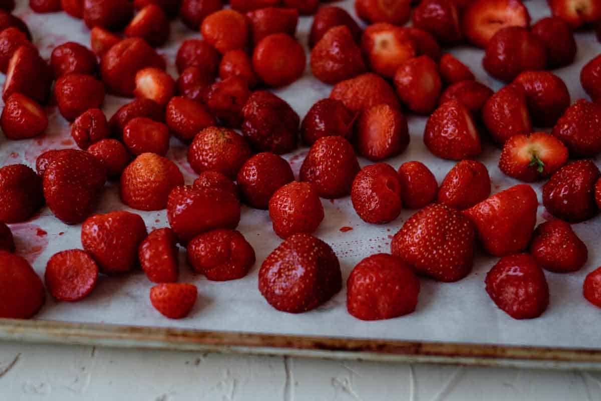 fresh strawberries on baking sheet ready to be frozen.