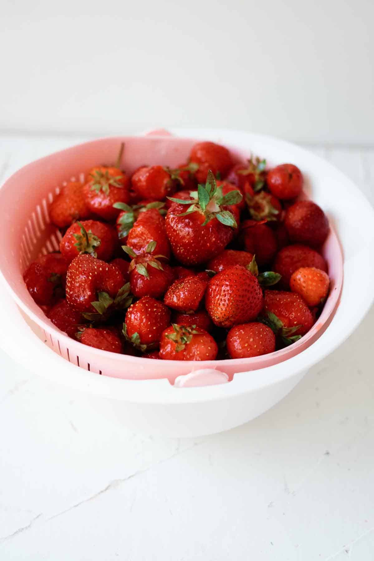 washing strawberries in strainer.