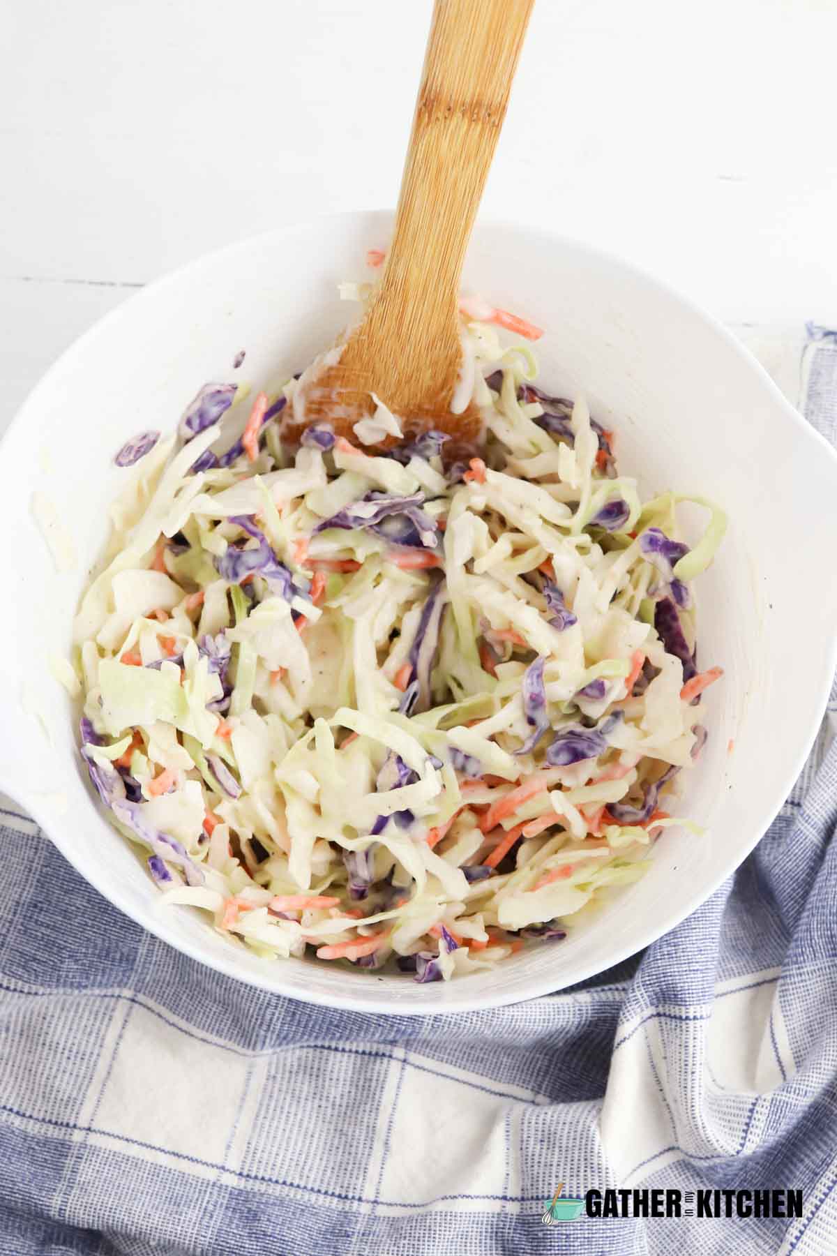 Cole slaw mix and dressing mixed together in bowl.
