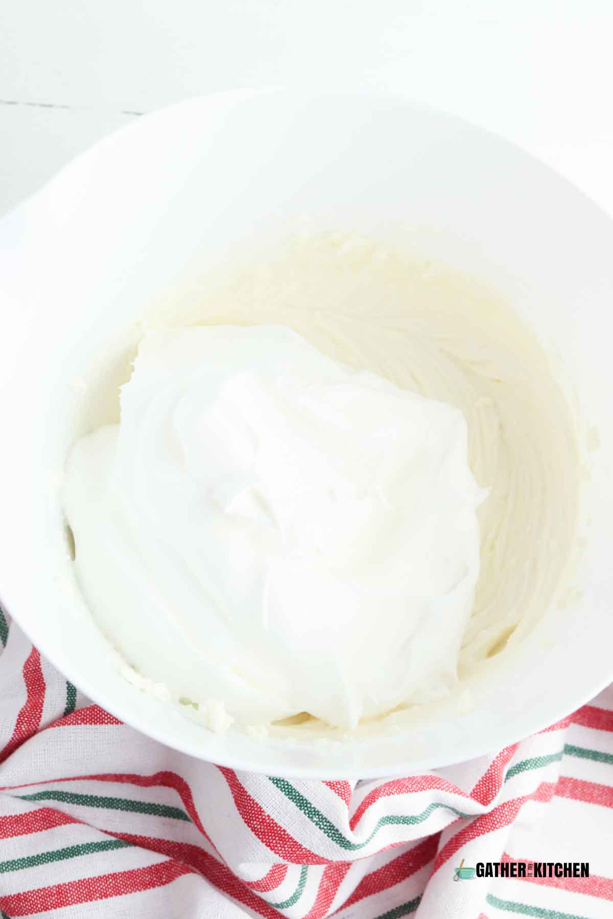 whipped topping on top of the cream cheese mixture in bowl.