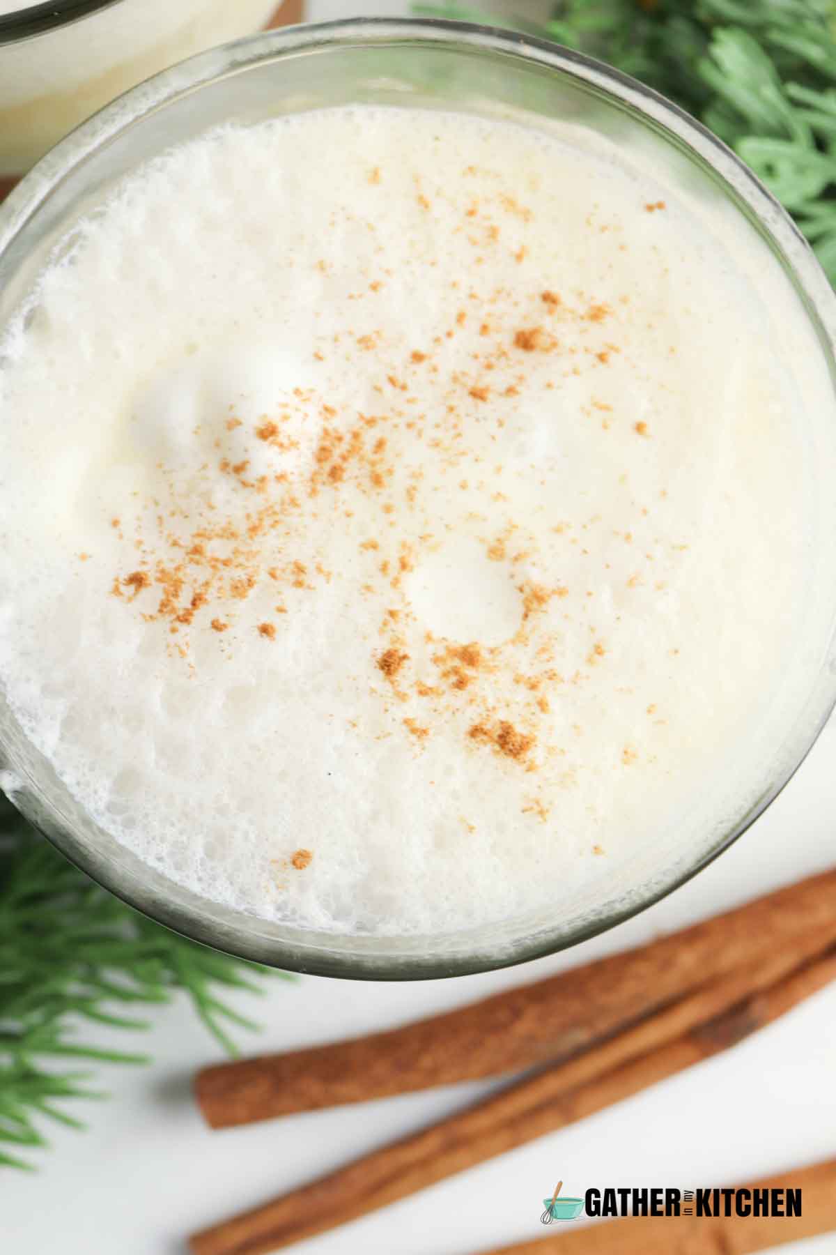 Top down view of eggnog punch in a glass.