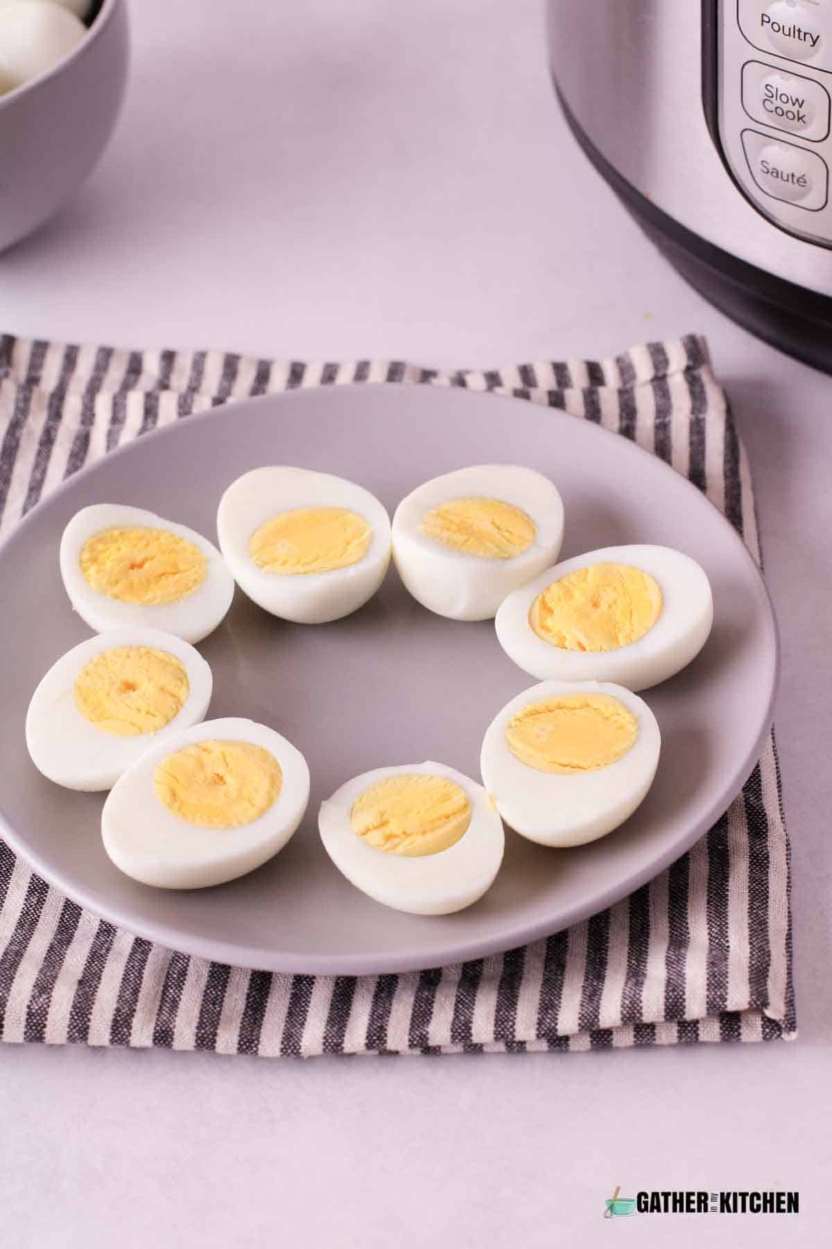 Instant Pot hard boiled eggs cut in half on a plate.