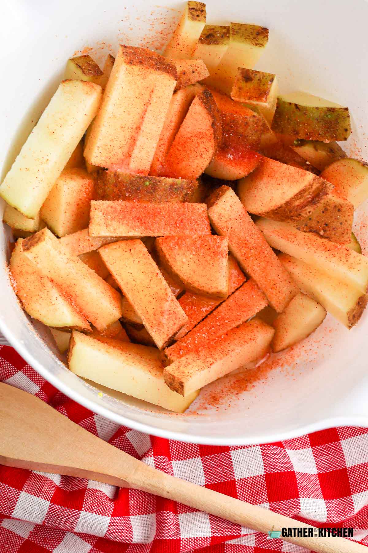 Cut up potatoes in a bowl with seasoning on top.