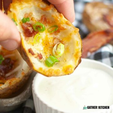 Air fried potato skin being dipped into ranch.