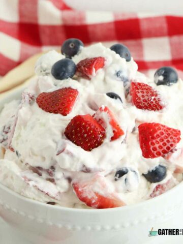 A bowl with berry cheesecake salad with strawberries and blueberries visible.