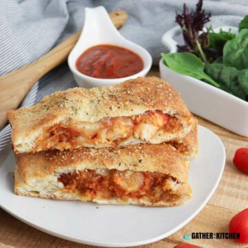 Two slices of chicken parmesan stromboli stacked on a plate.
