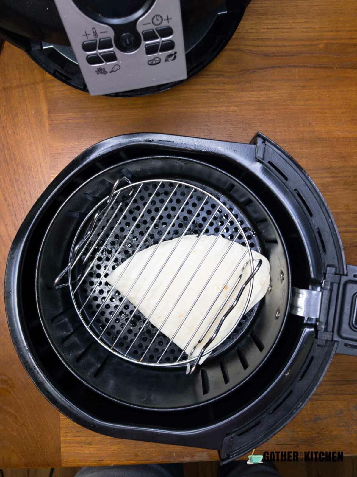 Quesadilla in air fryer with a grill rack on top of it.