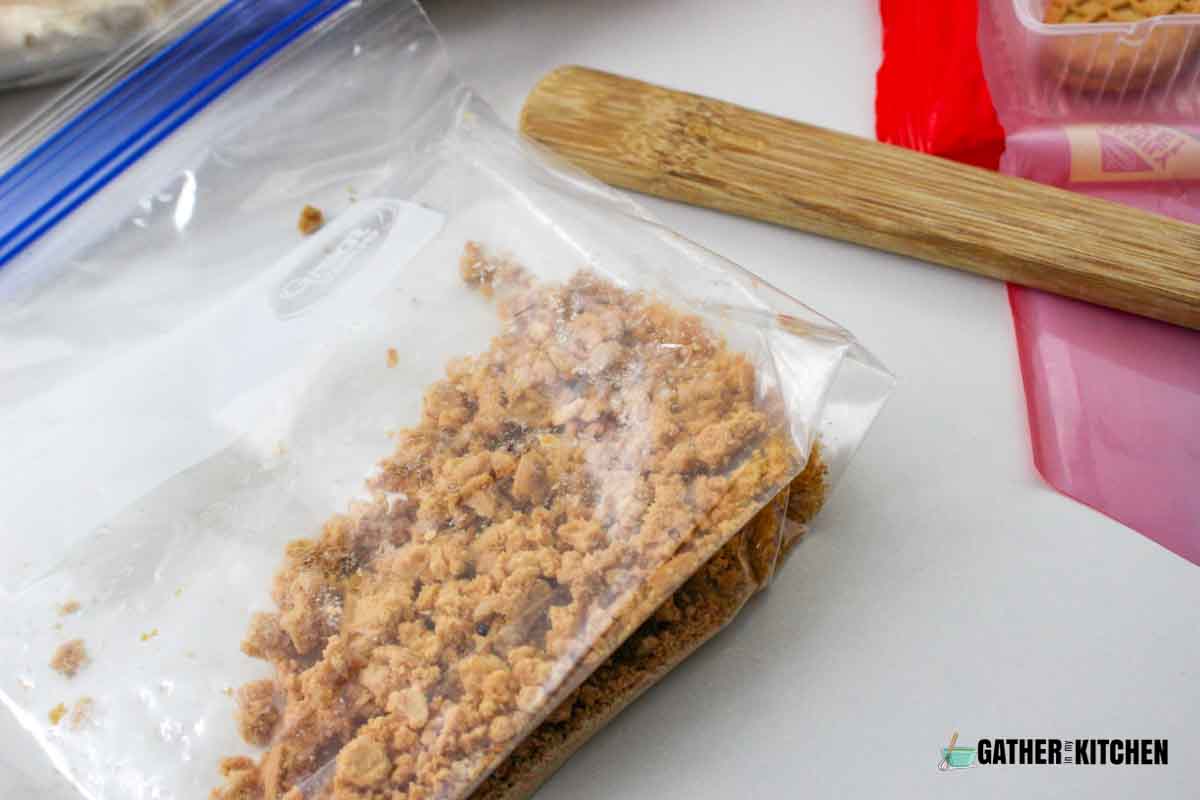 baggie with crushed Nutter Butters and a rolling pin next to it.