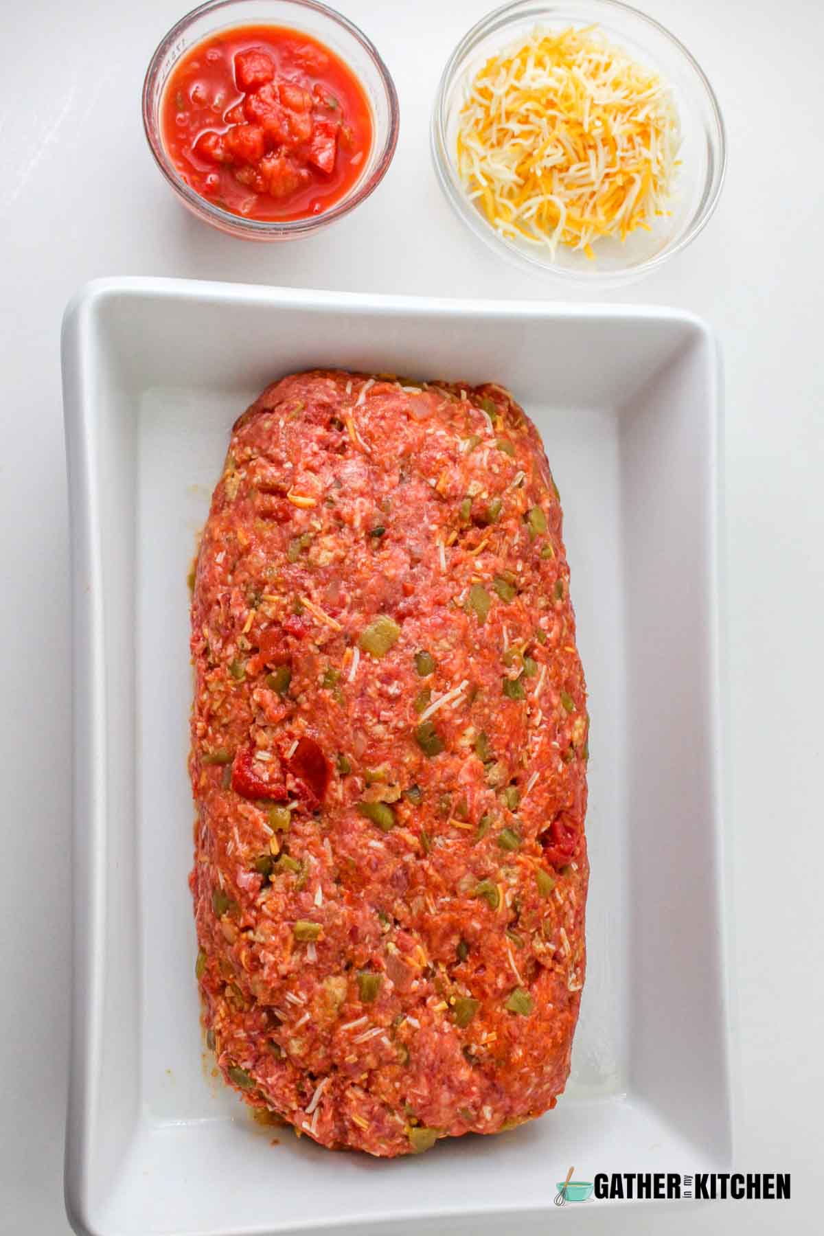 Meatloaf formed into log and placed in center of a casserole dish.