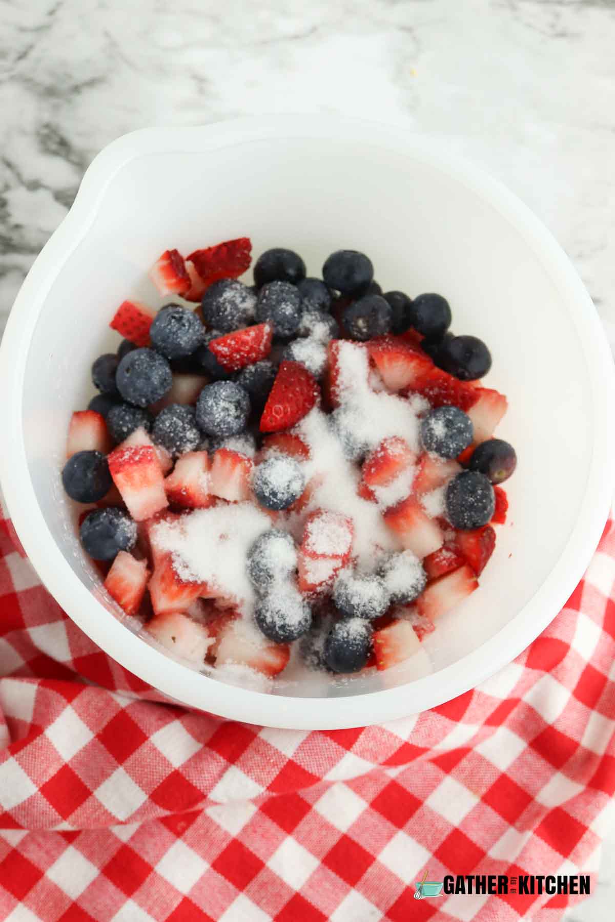Bowl with strawberries and blueberries with sugar sprinkled over the top.
