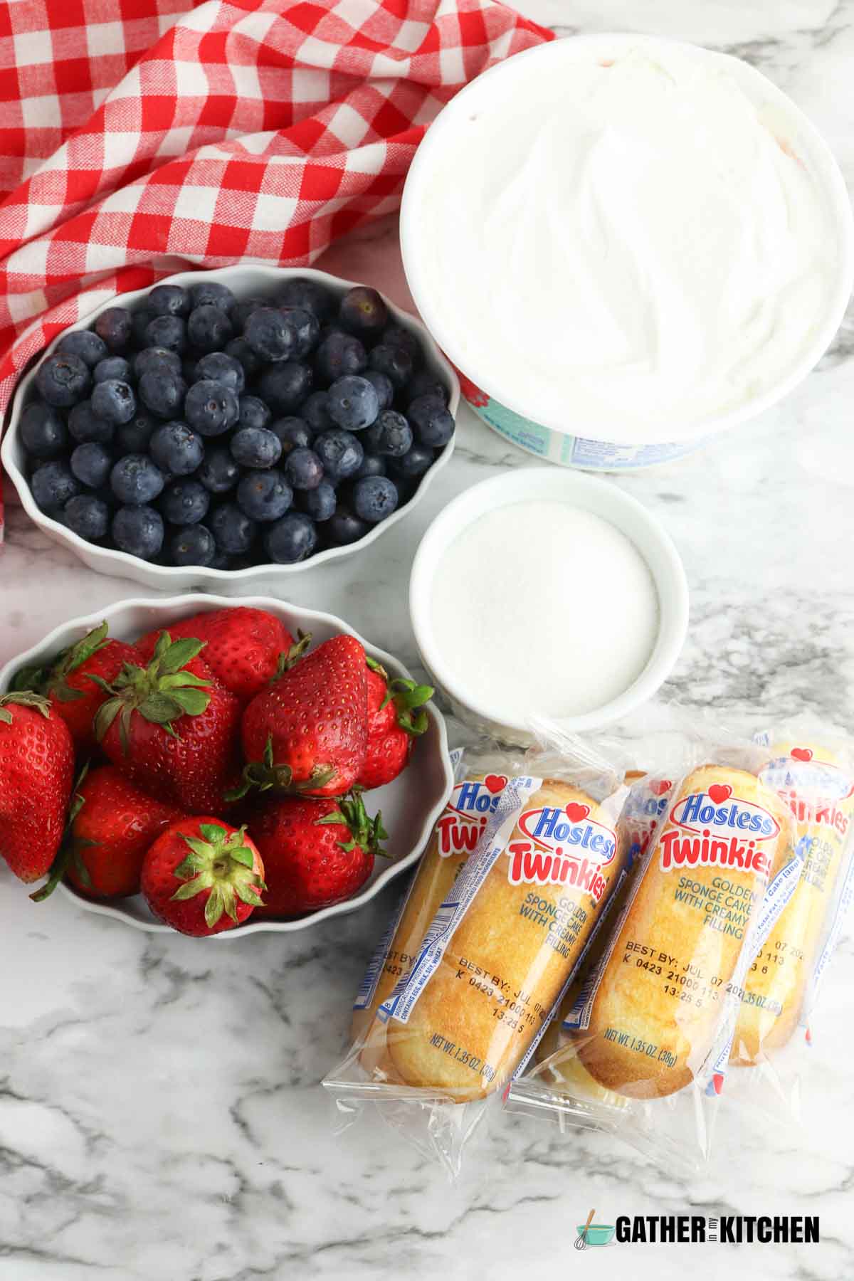 Ingredients for Twinkie shortcake: whipped topping, blueberries, sugar, strawberries and Twinkies.