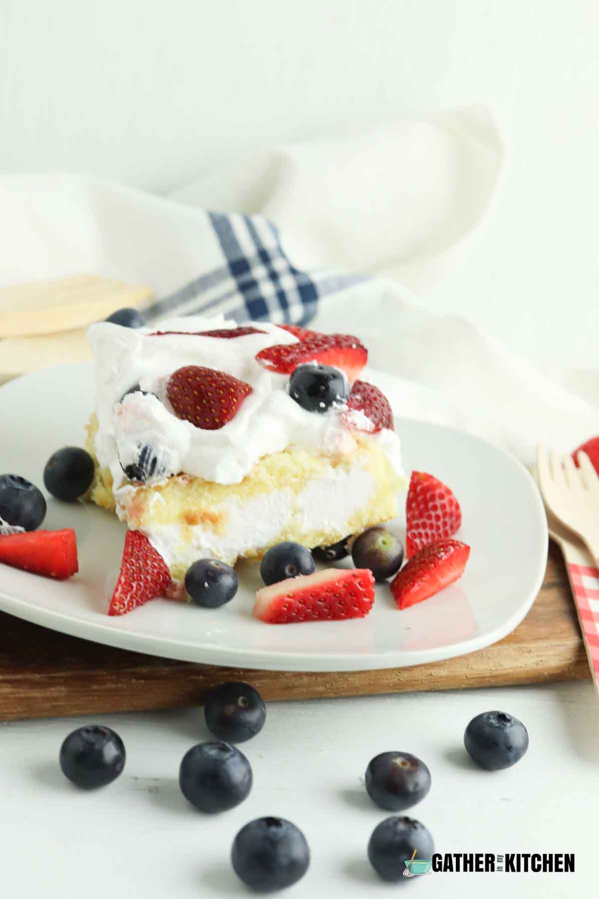 Piece of twinkie shortcake with strawberries and blueberries on a plate.