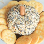 Pumpkin cheeseball on a plate with Ritz crackers surrounding it.