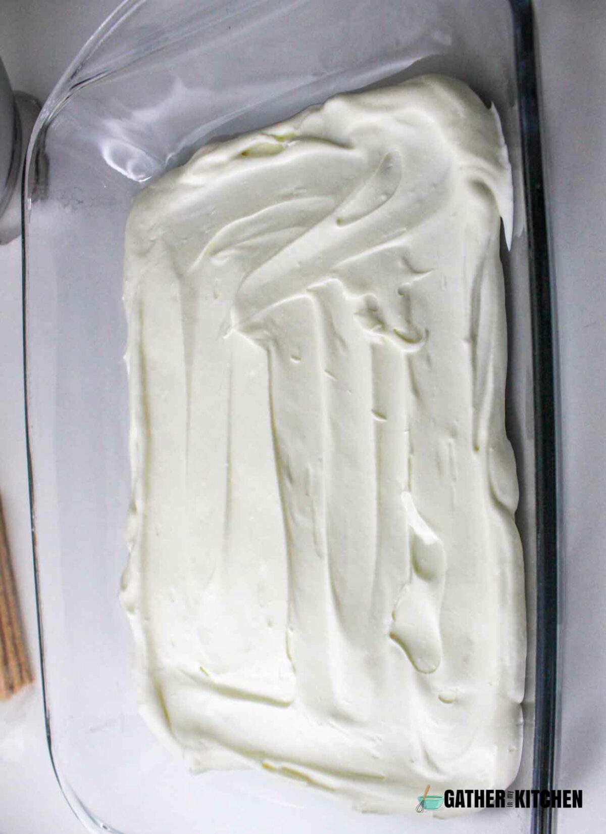 Marshmallow cream layer over graham crackers in dish.