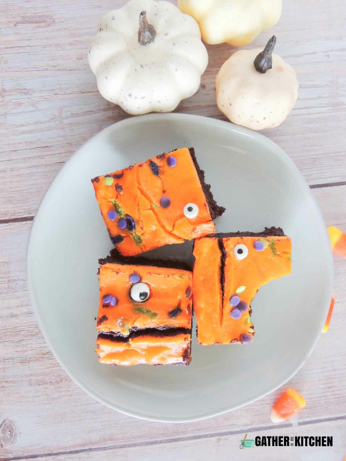 A plate of spooky brownies with one brownie with a bite taken off.