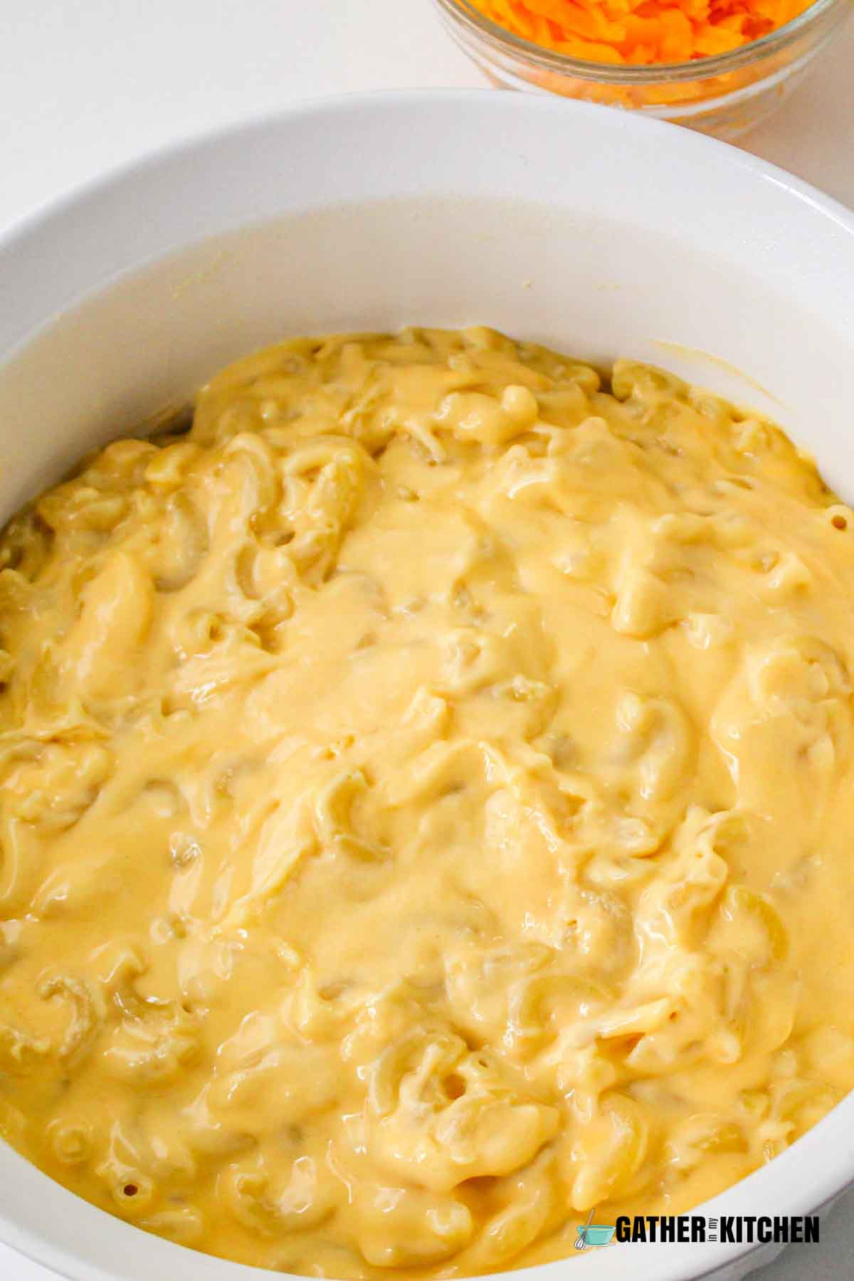 Cheese sauce over cooked macaroni.