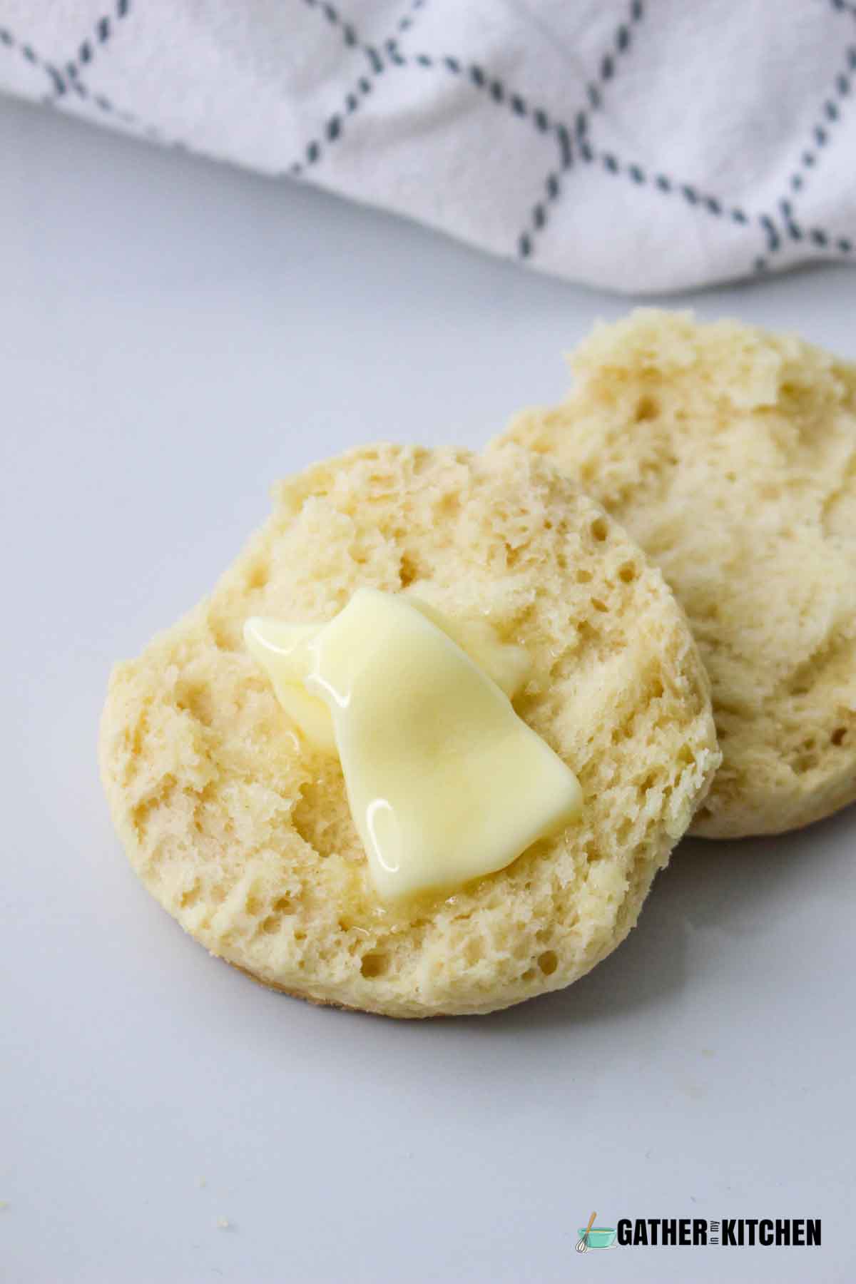 A crisco biscuit sliced in half with butter on it.
