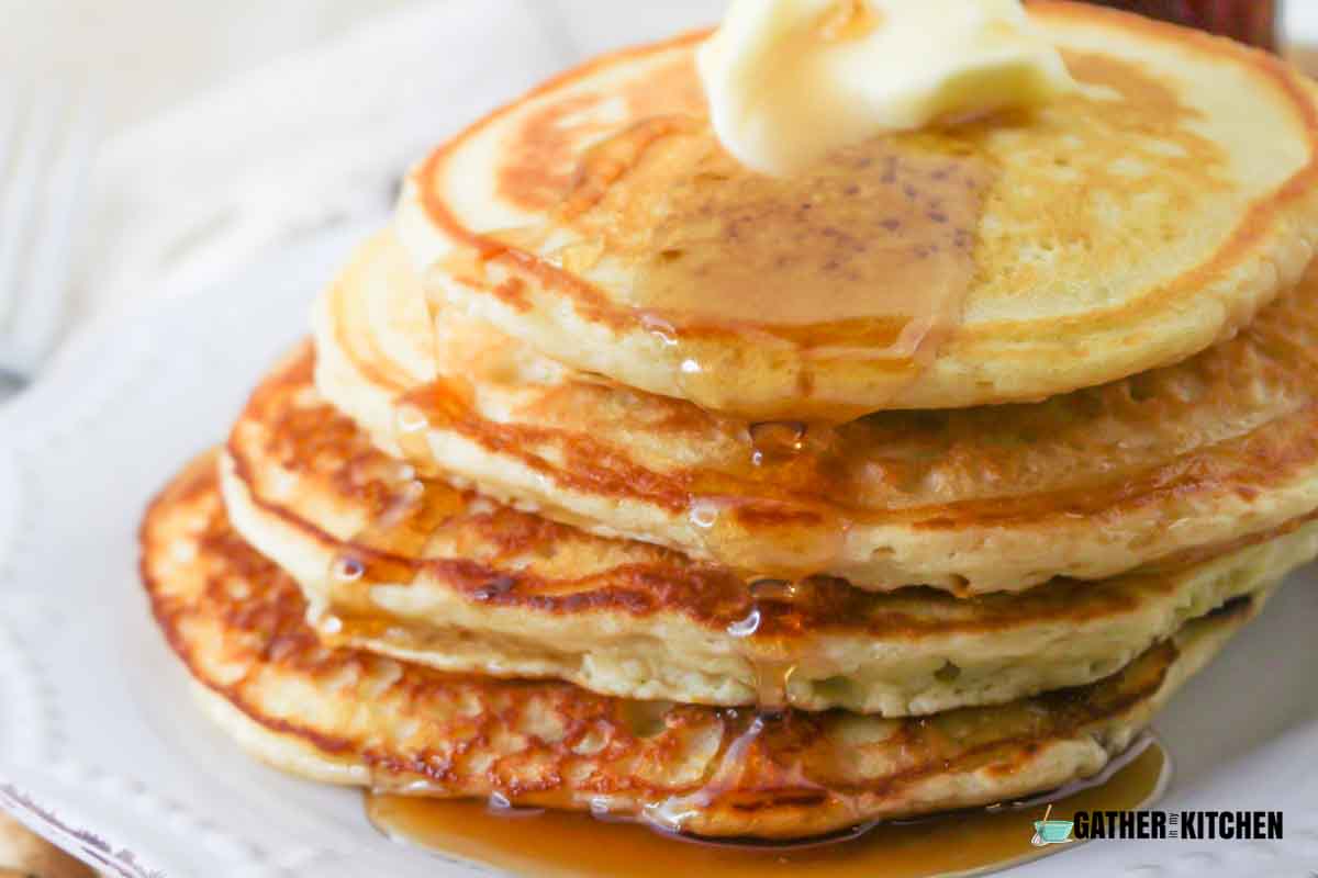 A stack of buttermilk pancakes with butter on top.