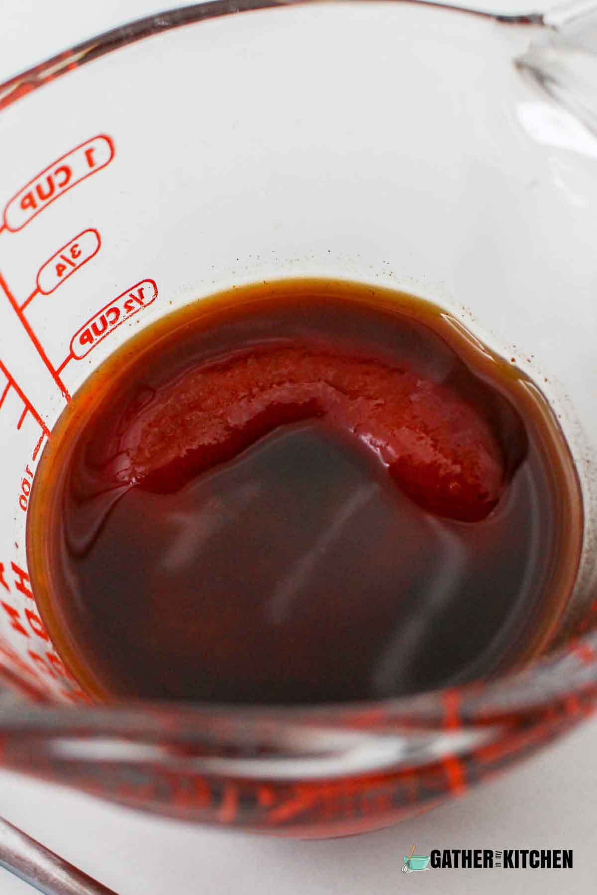 Ketchup, hot sauce, and Worcestershire sauce in a measuring cup.