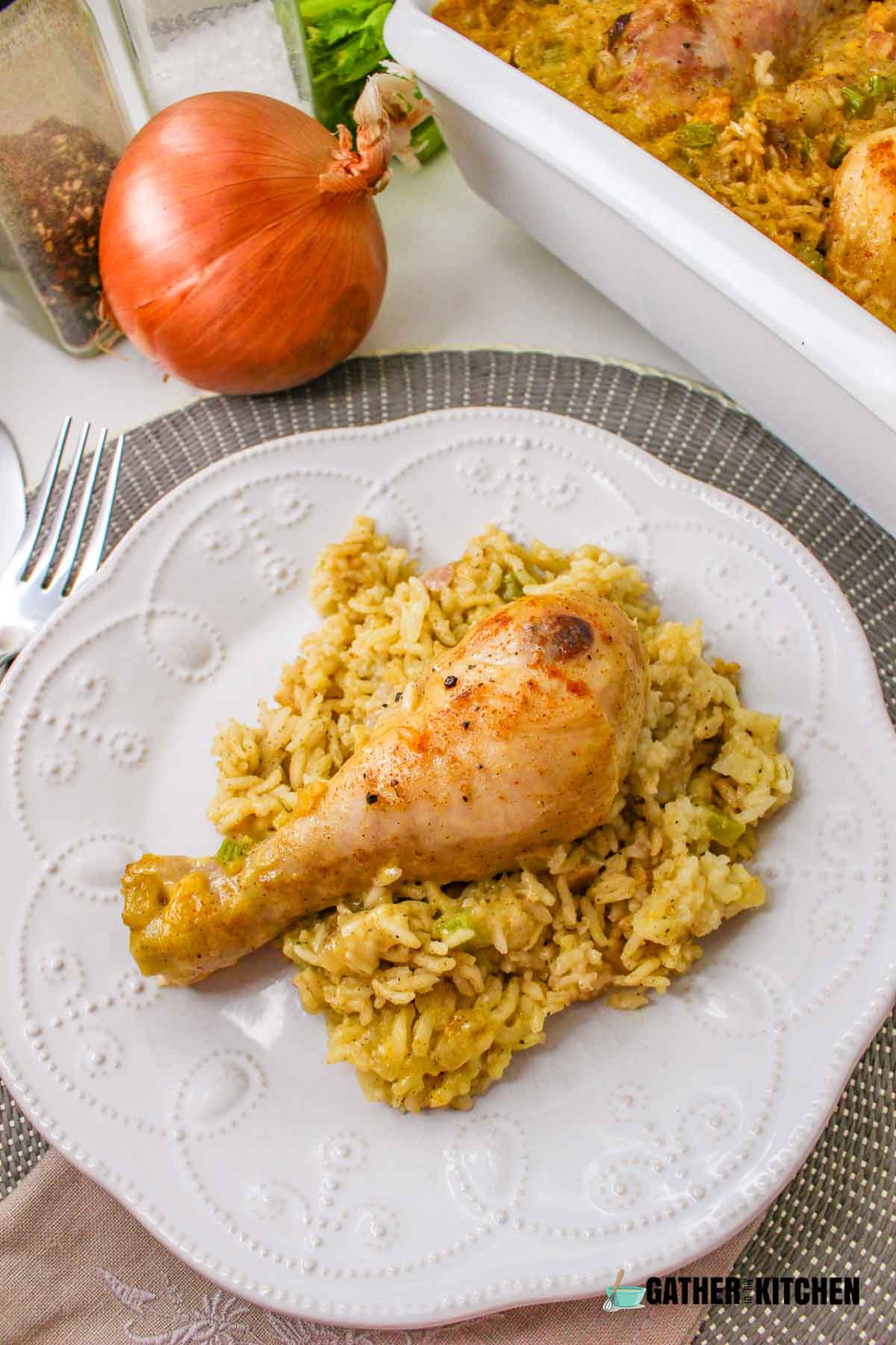 A piece of creamy chicken drumstick on a bed of rice.