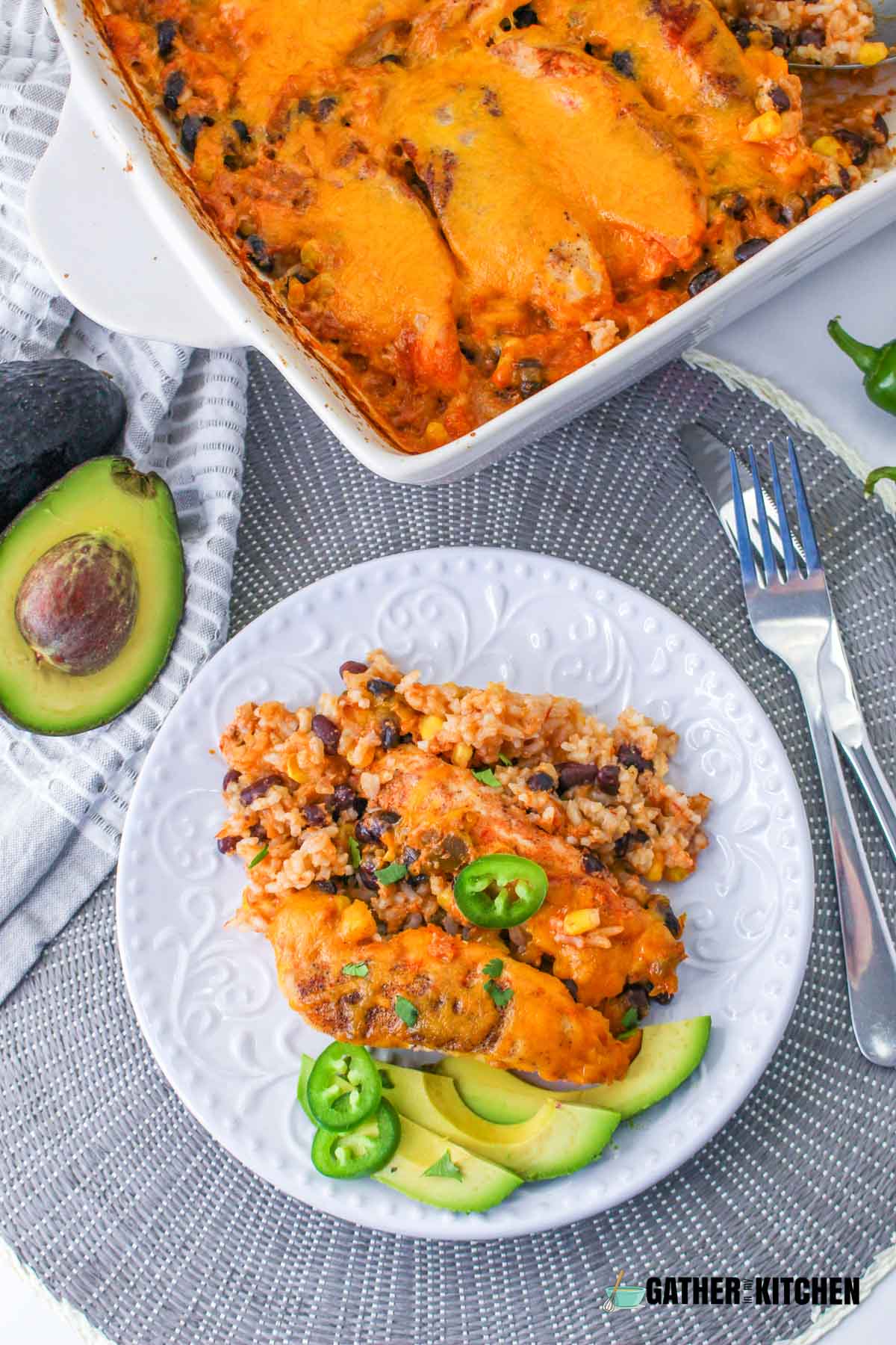 A serving of fiesta chicken & rice casserole on a plate with a fork and knife on the side