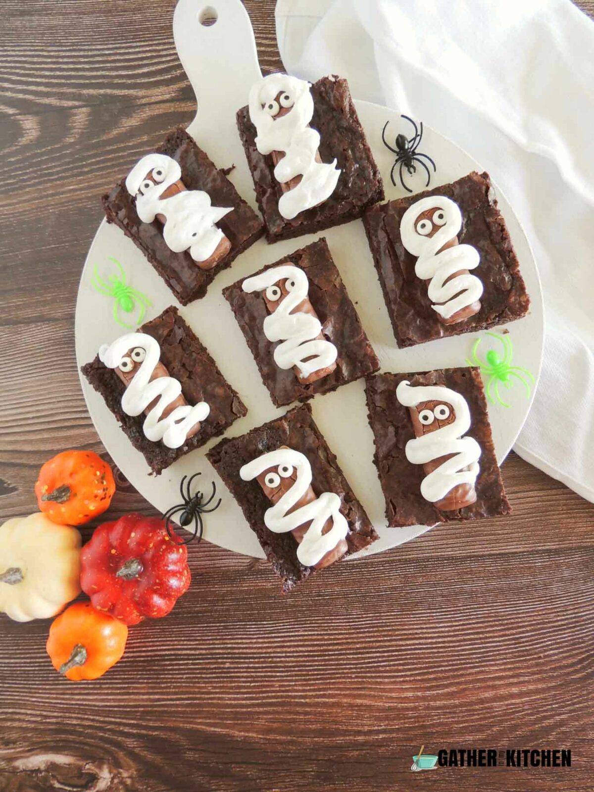 Six mummy brownies on a plate.
