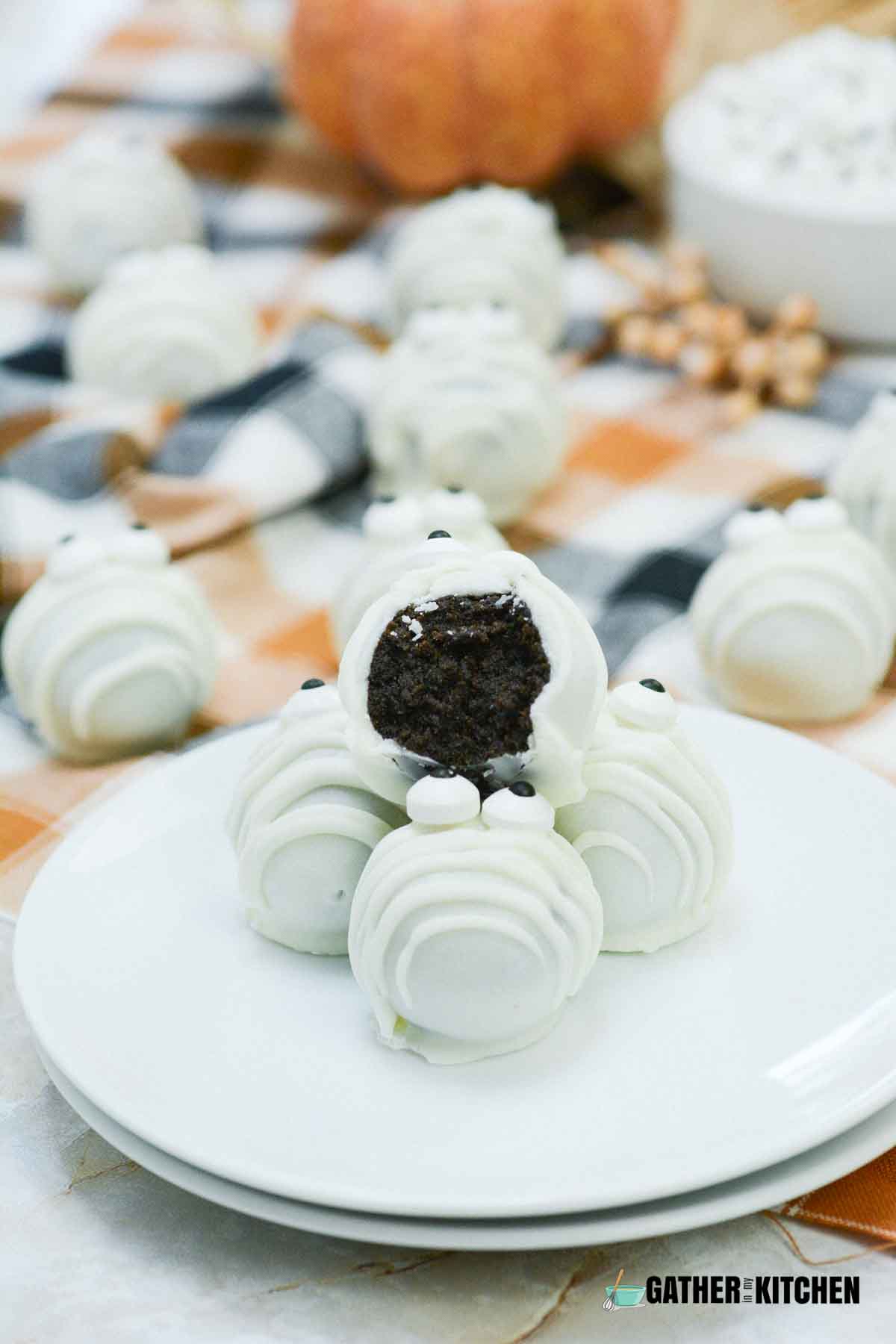 Mummy truffles on a plate with one with a bite on it.