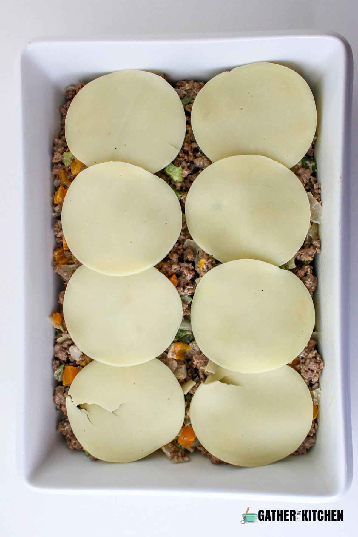 Slices of provolone cheese over beef and veggie mix.