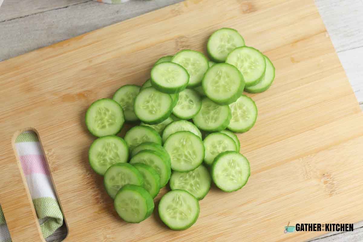 Slices of cucumber on a chopping board.