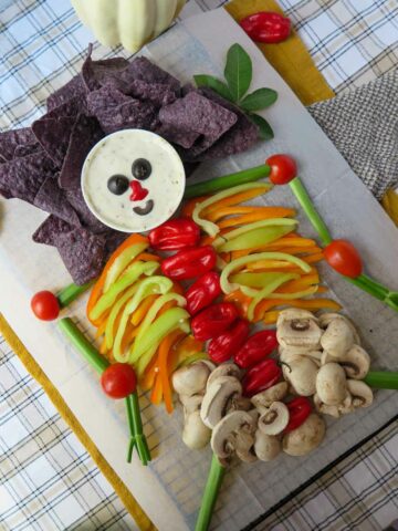 A spread of chips, dip and vegetables forming a skeleton.