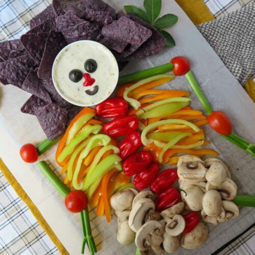 A spread of chips, dip and vegetables forming a skeleton.