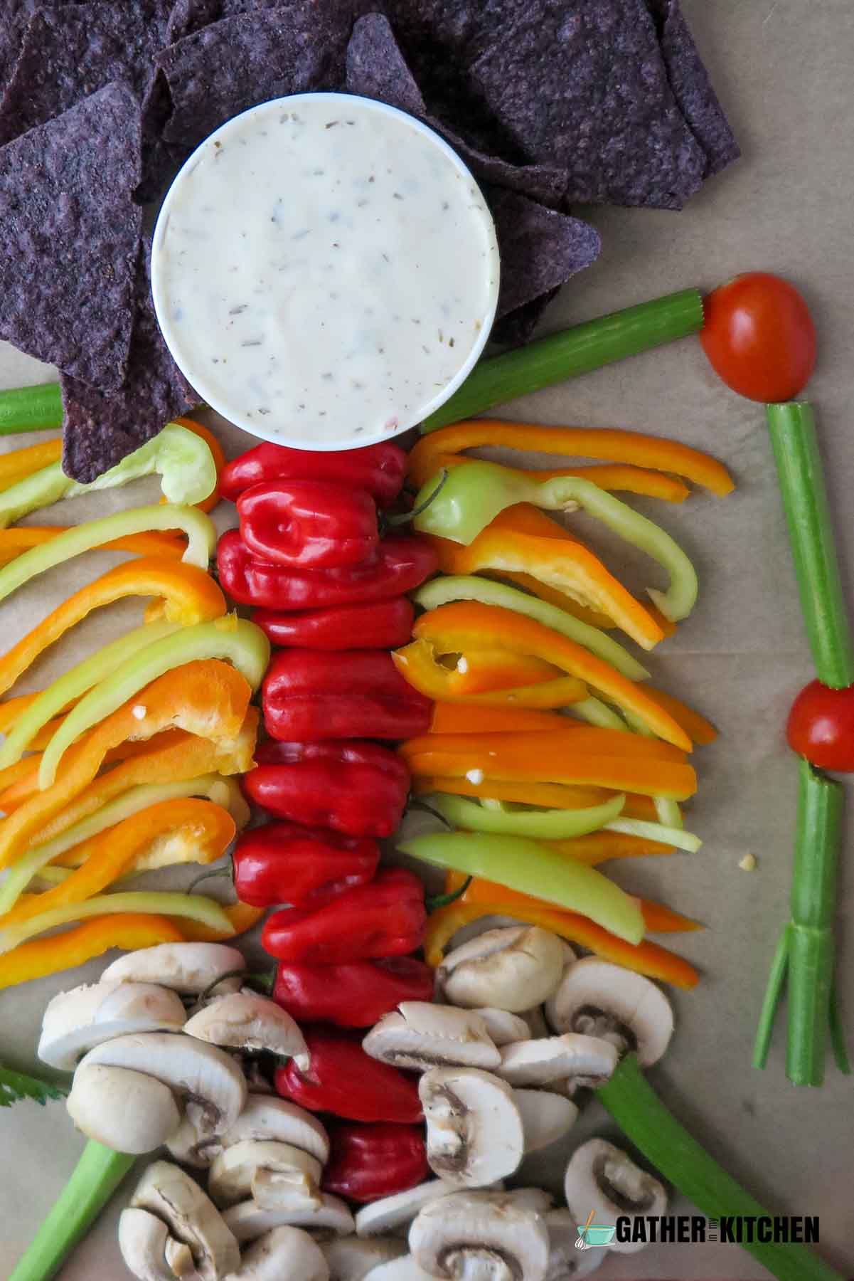 Chips, bell peppers, mushrooms and veggie bowl arranged to form a skeleton.
