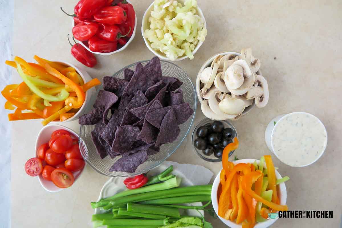 Ingredients: veggie dip, chips, olives, bell peppers, celery, mushrooms, cherry tomatoes, lettuce, cauliflower, 