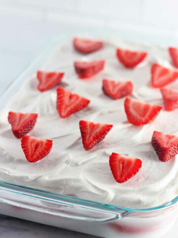 A closeup of a tray of strawberry ice cream cake