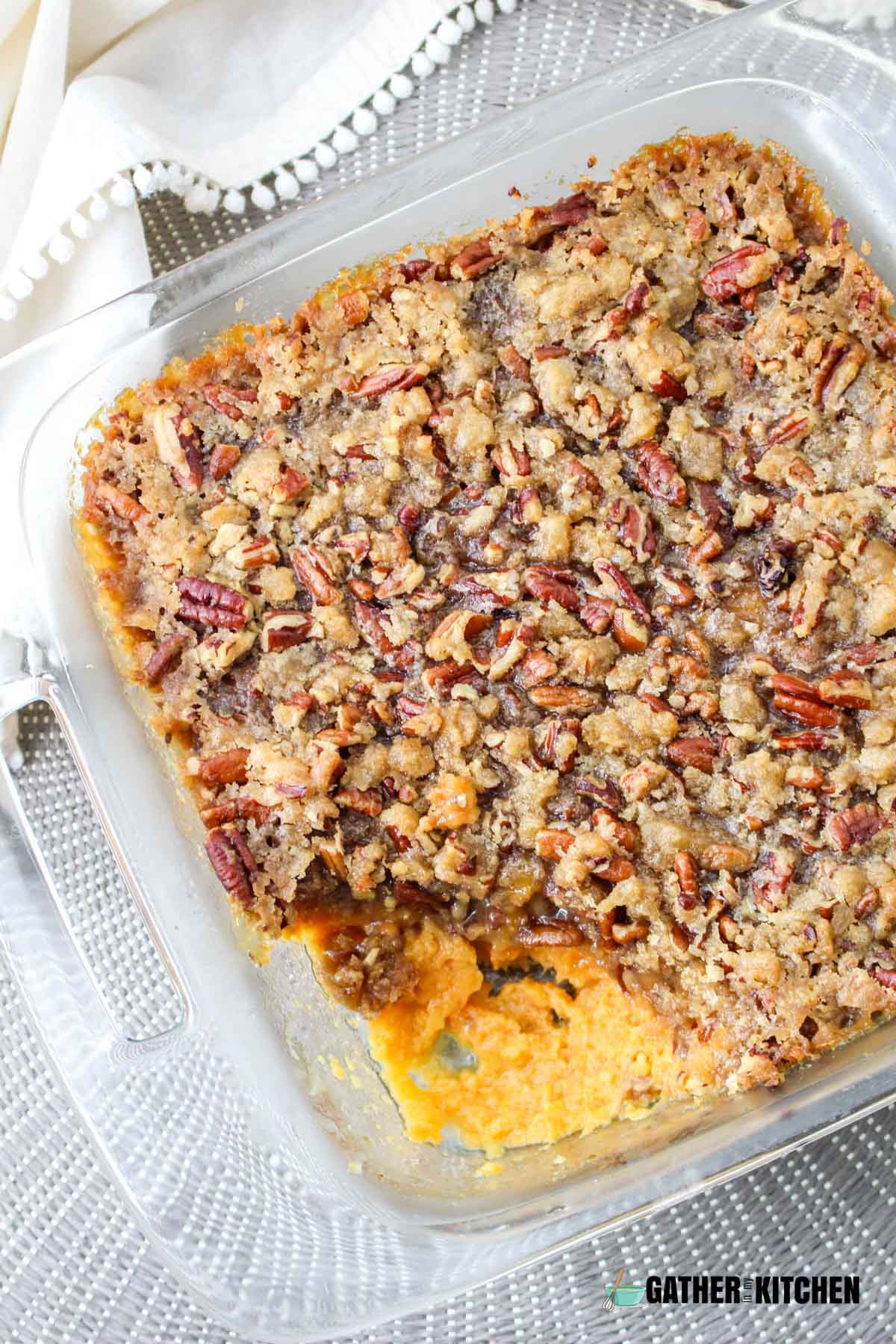 A tray of sweet potato casserole with a portion taken out.
