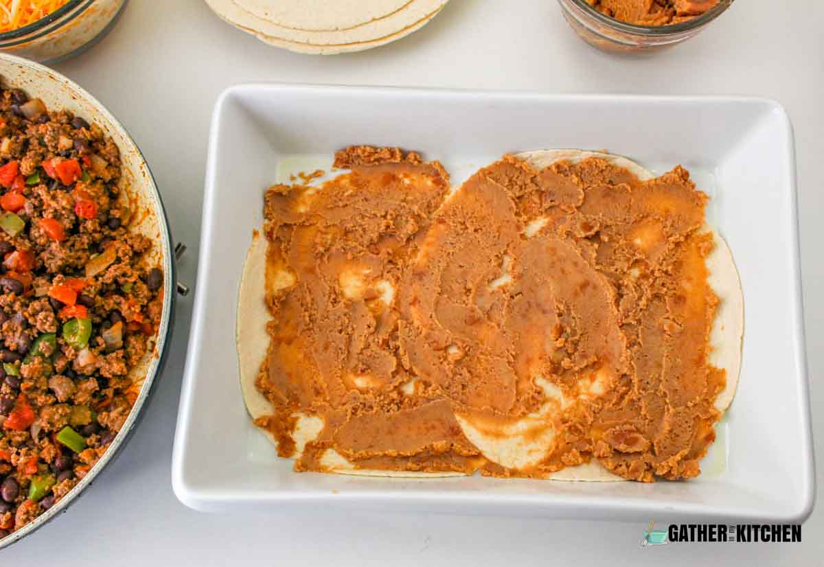 Tortillas with refried beans spread on it.